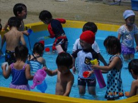 水を入れたり、流したり・・・「か～わって!」交替し合って水遊びを楽しむたんぽぽ組さん（幼稚園年少）