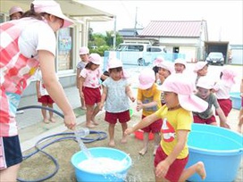 たらいにボディーシャンプーを入れて、ホースでジャジャ～!「わあ～、あわがでてきた～」（保育園年少　さくら組）