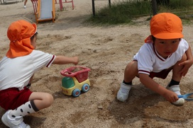 「トラックに（土を入れて）運ぶんだよ～」真砂土の山も子どもたちにとっては格好の遊び場です。