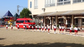 幼稚園は、駐車場倉庫付近へ避難します。煙を吸い込むのを避けるために口を覆っている子どももいました。