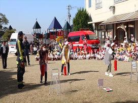 「せんせ～い、がんばって～」子どもたちの声援を受けて、水消火器の実演開始！吉賀・河本・千々松先生、見事、命中！